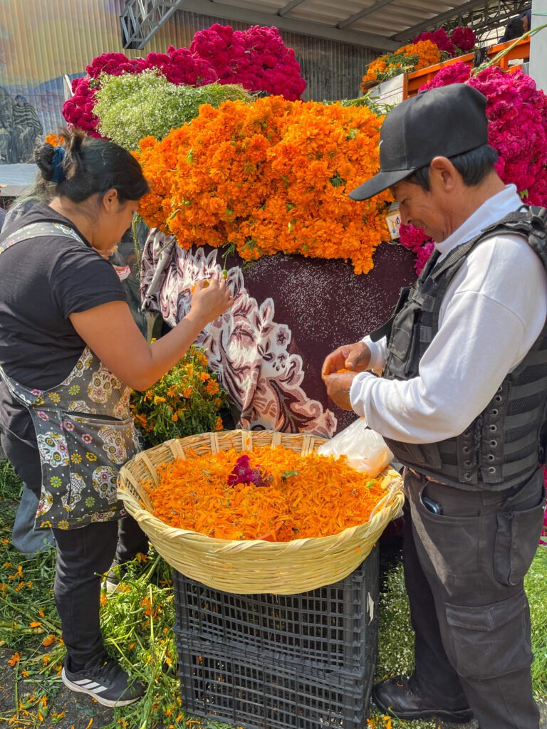 Vendors pick off marigold petals for Day of the Dead celebrations.